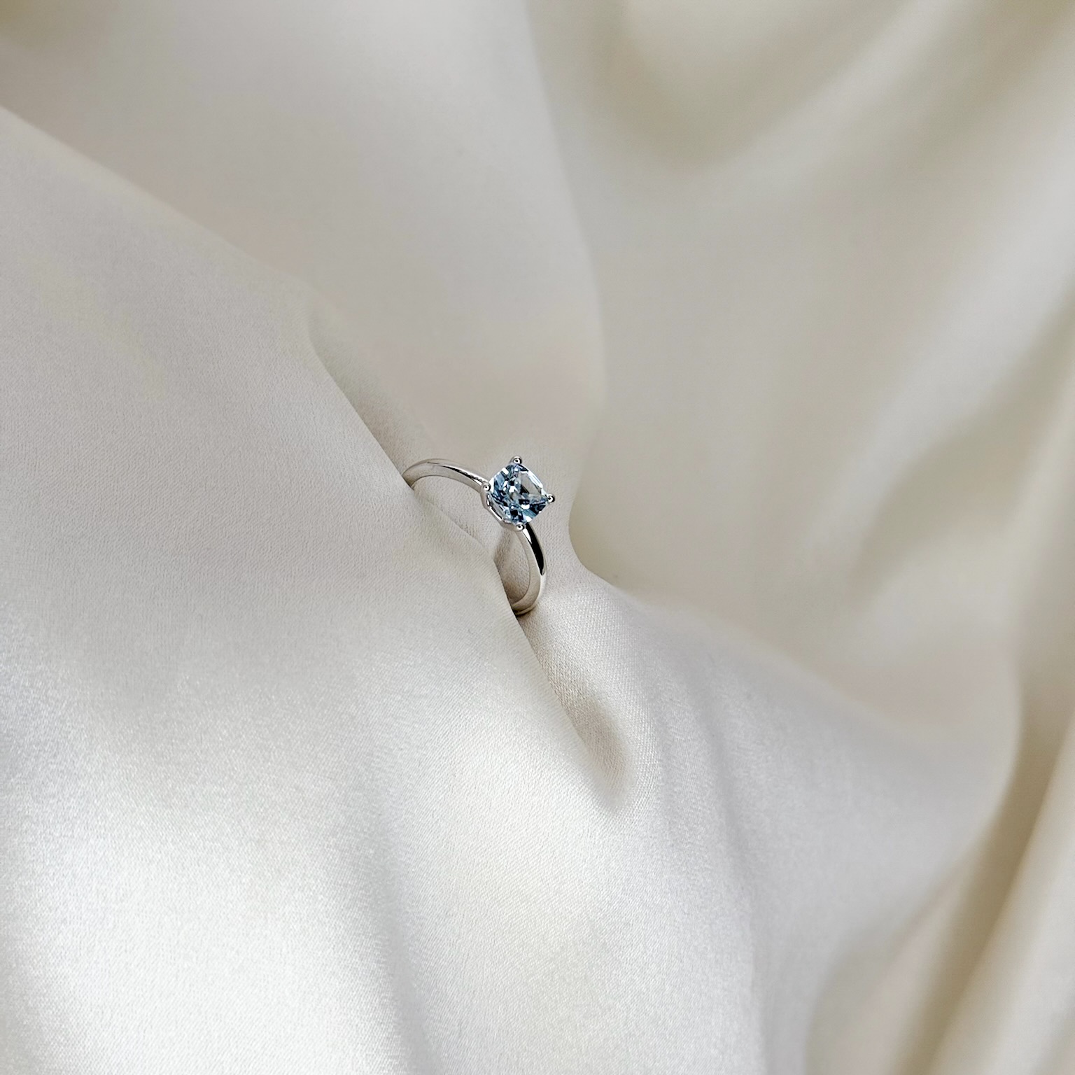 A handcrafted white gold ring featuring a 1.00 carat aquamarine in carré cut, renowned for its elegant square shape and radiant brilliance, displayed against a soft, neutral background to highlight its sophistication and timeless beauty.
